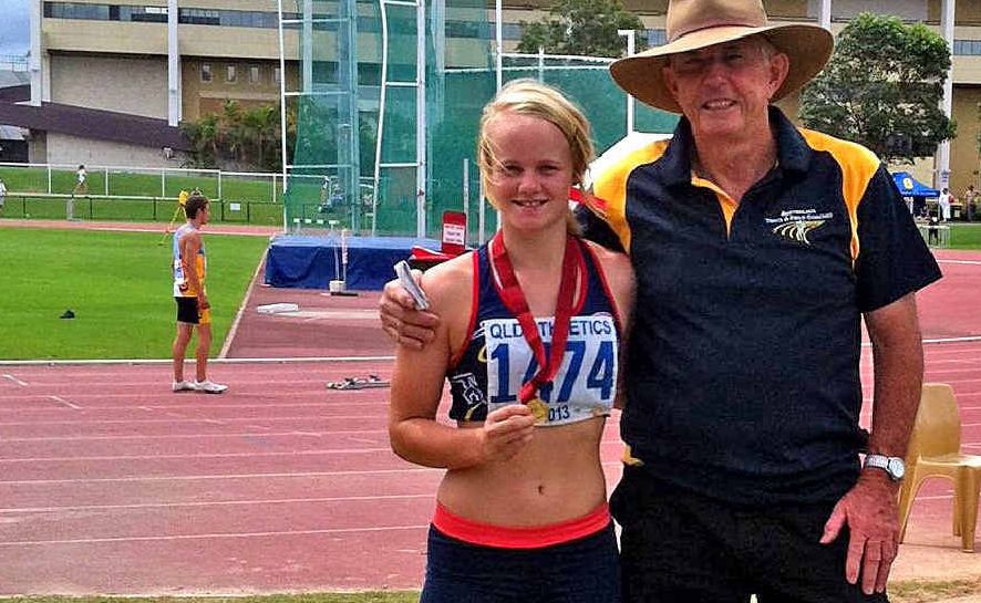 Emily Bass with coach Neil McCoy after winning the under-16 200m hurdles at the Queensland Junior Championships.
